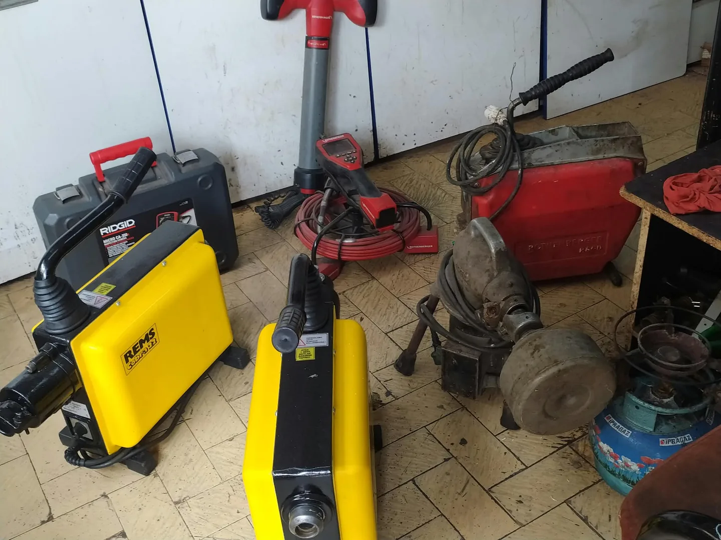 Yellow and red drain cleaning machines in the shop