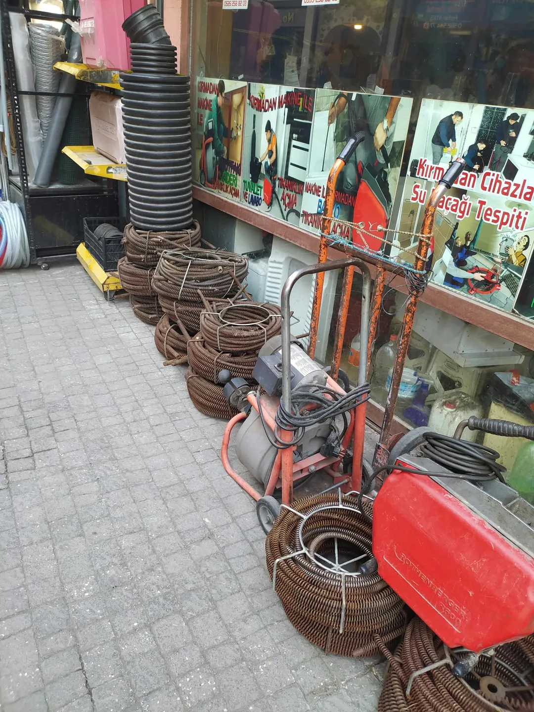 Drain cleaning machines and cables of various sizes outside the shop